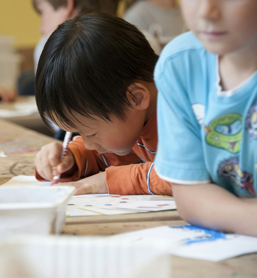 Photo d’un jeune élève en classe en train d’écrire